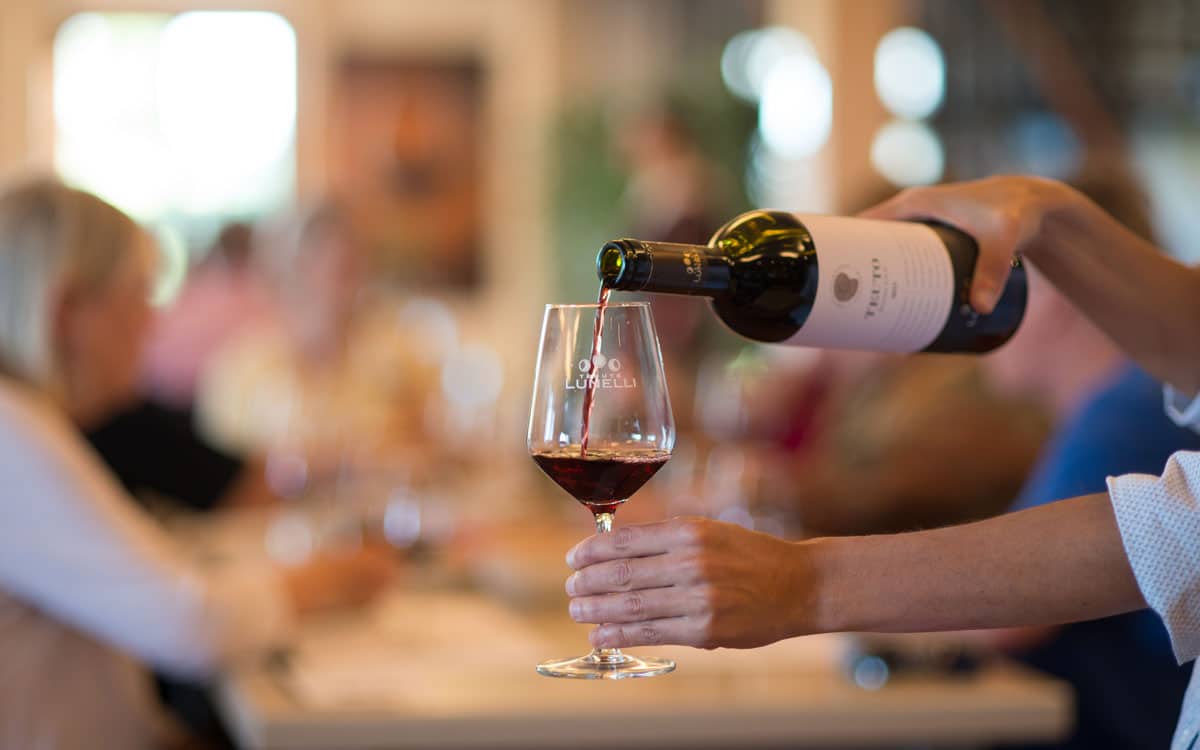 A person pouring wine for a guest at the Festa dell'Uva in Cinigiano