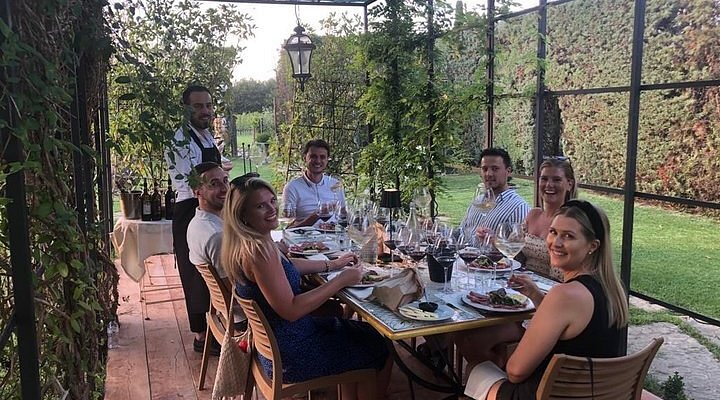 Guests at the Orcia Wine Festival having a meal and a wine tasting in a beautiful garden setting